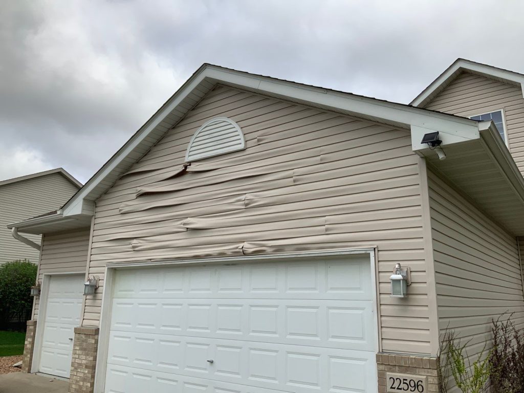 front of home with siding damage on Siding installation, Siding Renovation